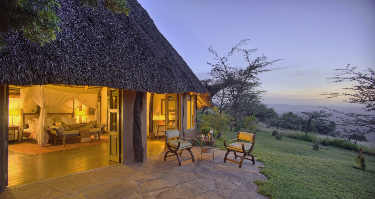 Warm light spilling from a thatched cottage in the evening