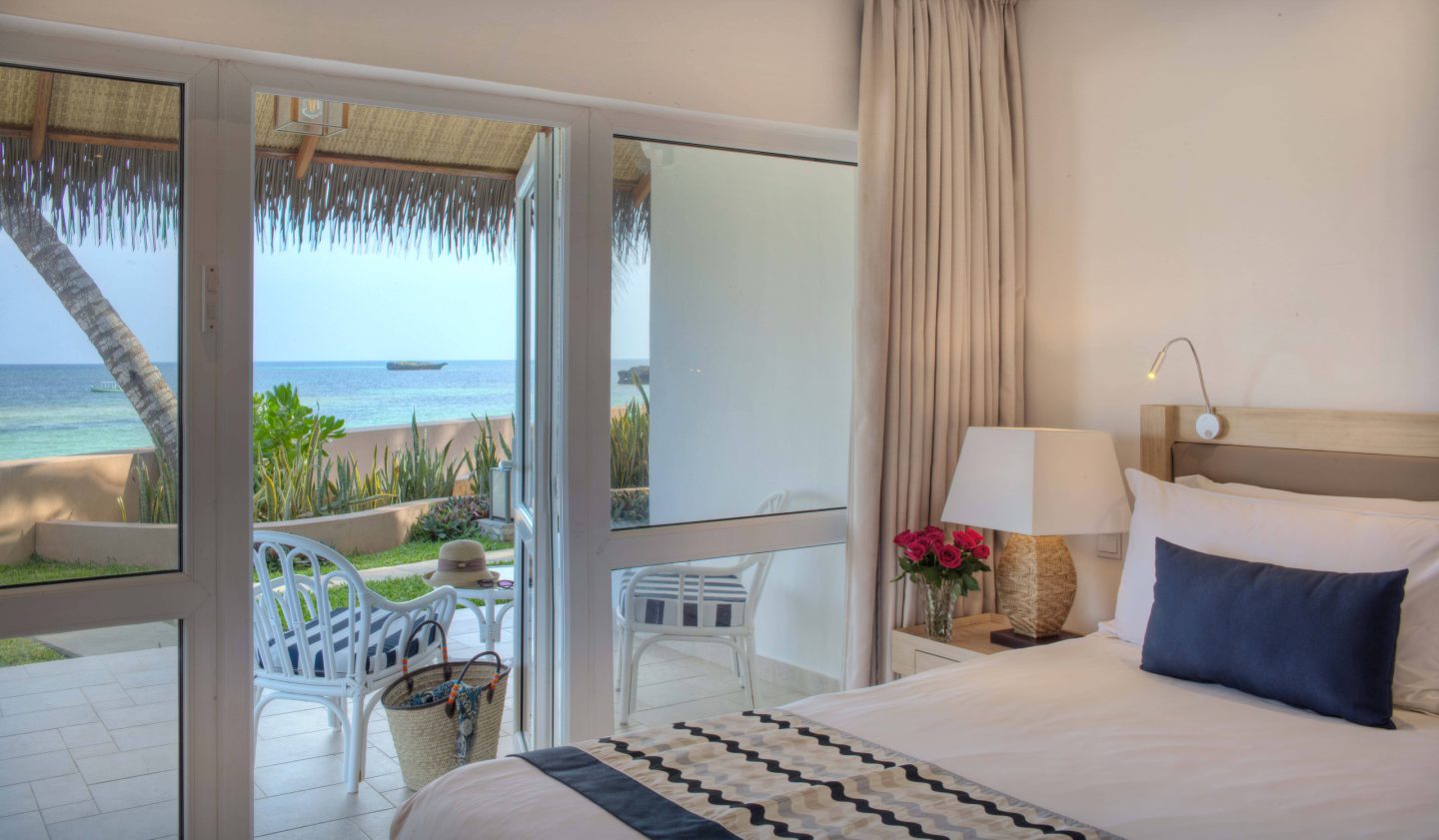 A suite balcony with a chair set to face the sea