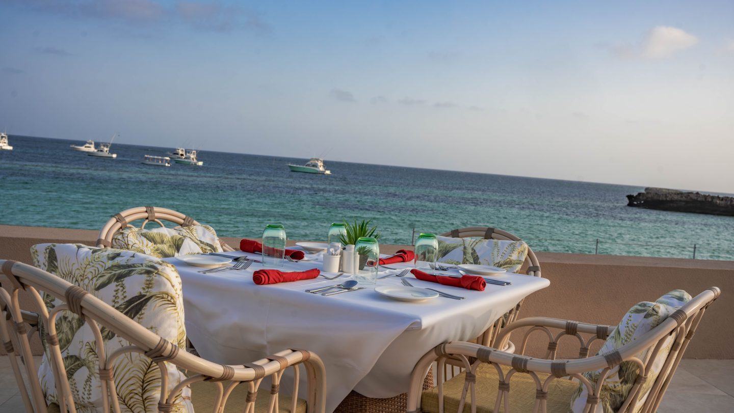 A table set for two on the sand beside the ocean
