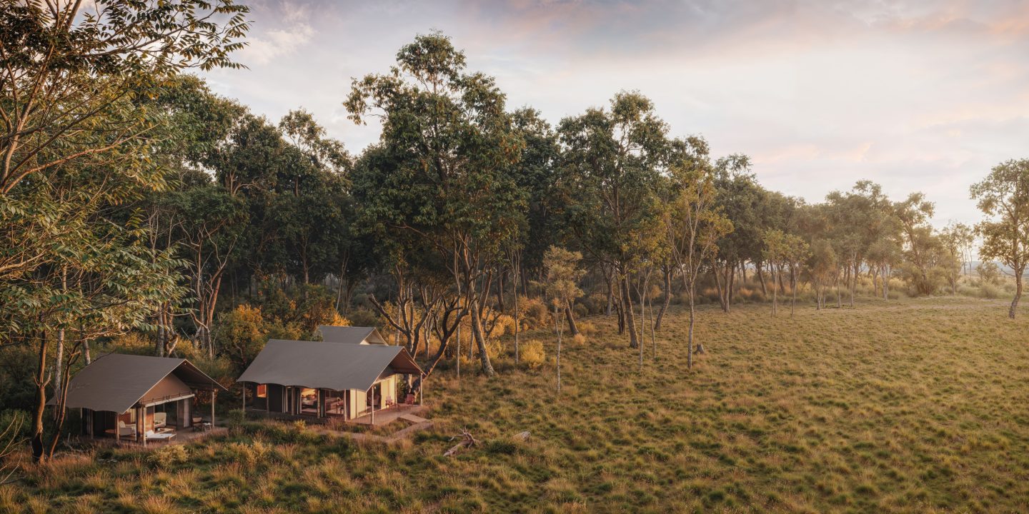 Safari tents scattered through open bush, seen from the air